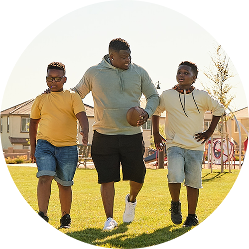 young men playing football at the park