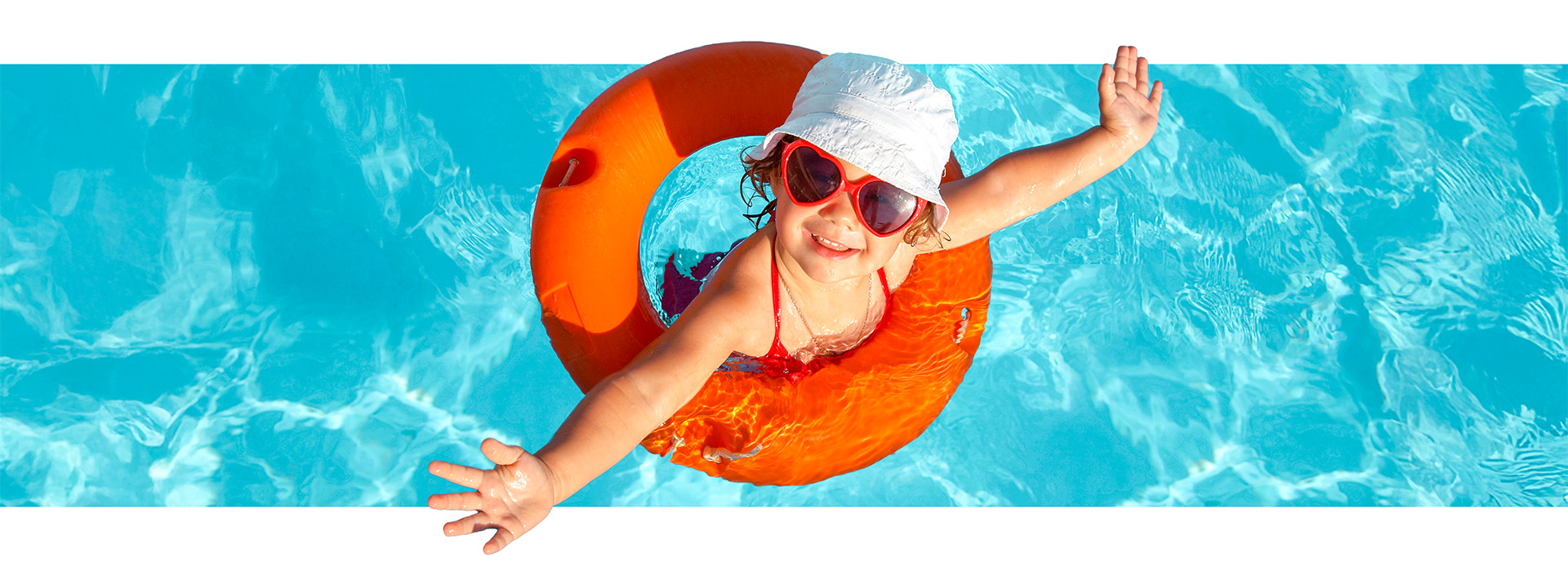 young child with sunglasses and tube enjoying the pool