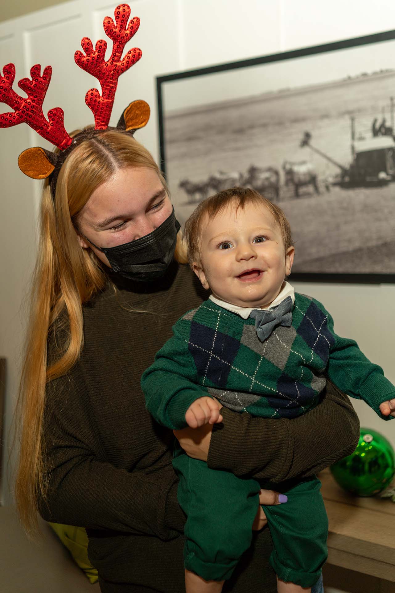 woman with reindeer headband holding a small child