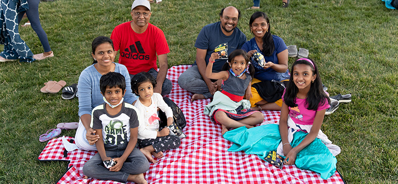 two families on picnic blanket - Movie Under the Stars - Tracy HIlls