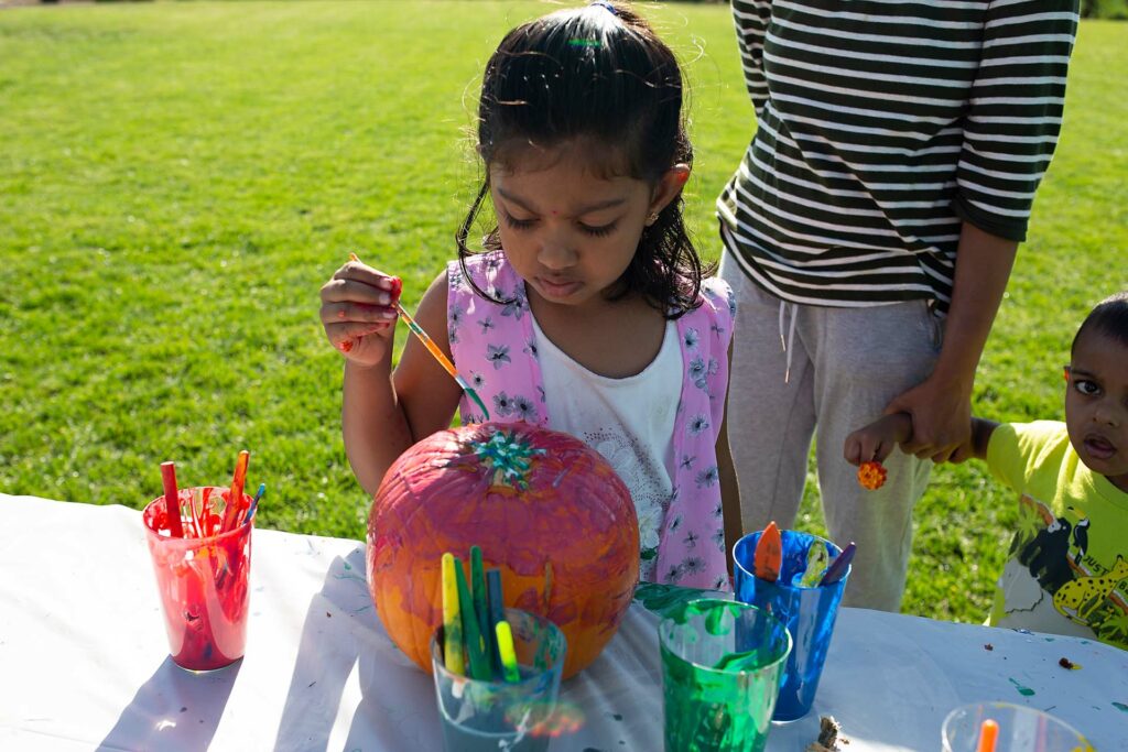Young girl paints a pumpkin at the Tracy Hills Fall Celebration